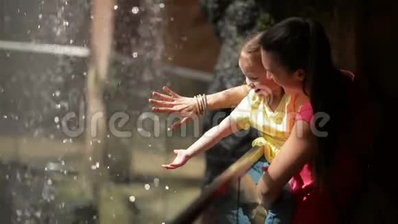 妈妈和可爱的女儿玩小瀑布他们在母亲节一起玩得很开心视频的预览图