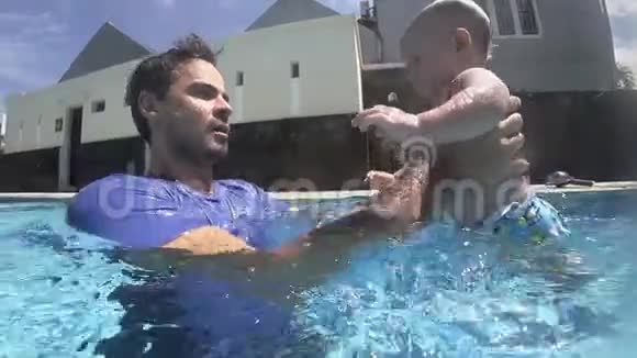 快乐微笑的新生男孩和父亲一起在水下潜水视频的预览图