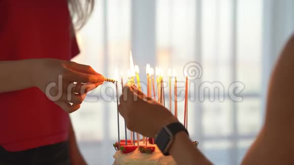 两个女孩在生日蛋糕上点蜡烛视频的预览图