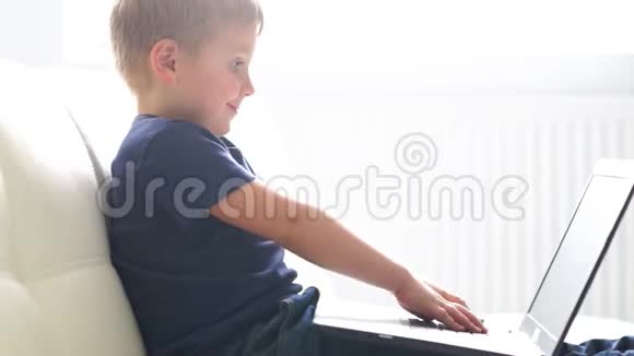 快乐男孩玩电脑的肖像有魅力的孩子家里有笔记本电脑娱乐技术未来主义视频的预览图