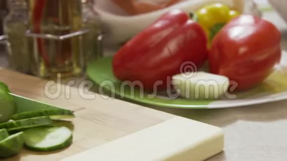 在木板上用刀切黄瓜把手收起来场景新鲜黄瓜放在木切割板上关门视频的预览图
