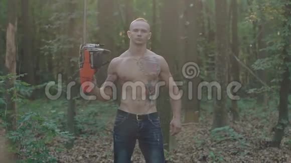 森林里手持电锯的野蛮人的肖像慢慢地视频的预览图