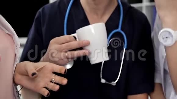 年轻医生午餐喝咖啡讨论他们的工作病人的治疗视频的预览图