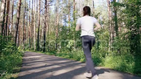 美丽的女孩在森林小径上奔跑视频的预览图