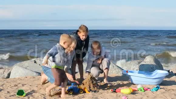 海滩上的家庭假日一个年轻的女人和她的儿子玩沙子视频的预览图
