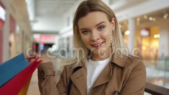 女孩在商场里拿着购物袋摆姿势看起来很可爱视频的预览图