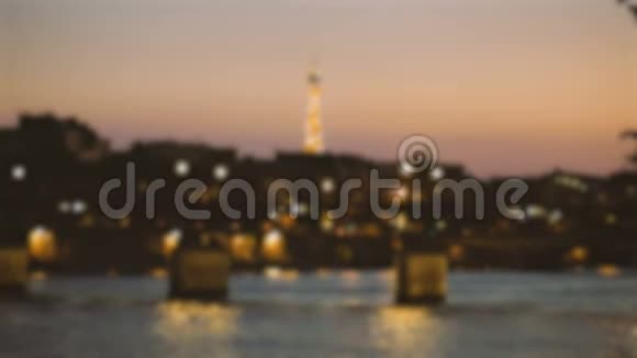 巴黎的消焦夜桥埃菲尔铁塔和晚上在塞纳河上经过的小船视频的预览图
