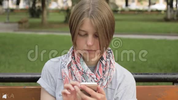 乔治亚州城市公园的年轻女子看着电话视频的预览图