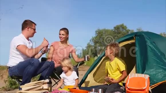 年轻的家庭在海滩上度过快乐的日子在户外吃晚饭视频的预览图
