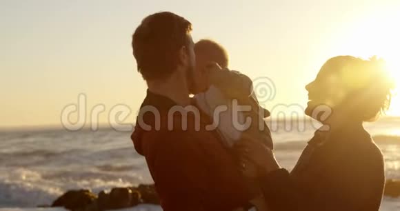 爸爸和妈妈在海滩上和他们的小男孩玩耍视频的预览图