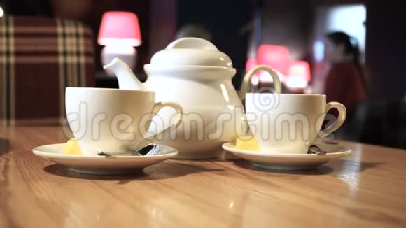 特写咖啡桌上的茶咖啡模糊的人物背景咖啡厅内部视频的预览图