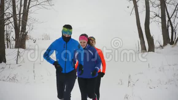 三名年轻运动员在冬季森林中进行技术训练视频的预览图