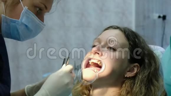 去看牙医牙齿矫正医生为一名有固定牙器的妇女安装铁支架视频的预览图