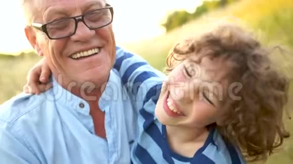 成熟的父子是个小学生已故的孩子一位快乐的祖父和孙子的特写肖像幸福家庭视频的预览图