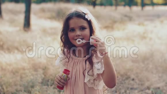 可爱的小女孩在吹肥皂泡视频的预览图