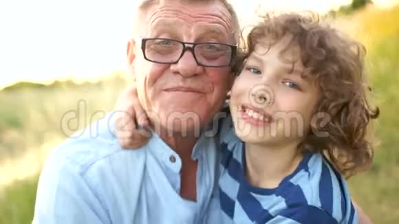 一位快乐的祖父和孙子的特写肖像成熟的父子是个小学生已故的孩子幸福家庭视频的预览图