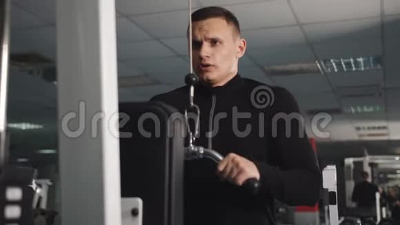 在健身房锻炼体重的人男性训练手臂三头肌使用电缆机进行身体质量工作安排视频的预览图
