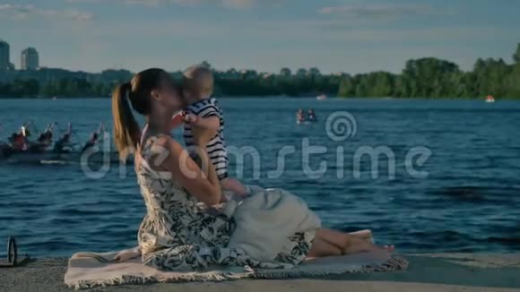 年轻的母亲带着孩子正在河上划独木舟的背景下休息视频的预览图
