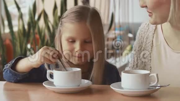 小女孩把勺子放在杯子里视频的预览图