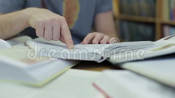 一个人手拿着一本书在阅读时沿着书页移动他的手指视频的预览图