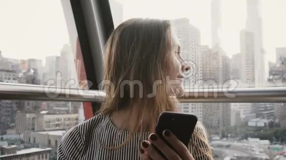 4K高加索游客女孩在空中阁楼迷人的微笑女士与智能手机在纽约岛电车视频的预览图