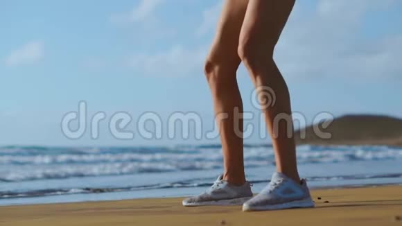 健身年轻女性锻炼核心和臀部与体重锻炼做深蹲运动在海滩上运动女孩视频的预览图