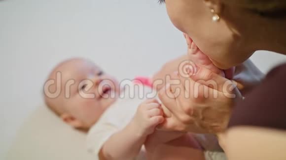 母亲亲吻婴儿的脚视频的预览图