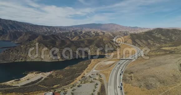沿着水库旁边的沙漠公路飞行视频的预览图