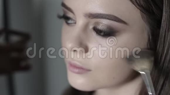 化妆师应用荧光笔年轻女孩做职业化妆视频的预览图