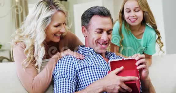 父亲打开礼品盒A与妻子和女儿在客厅视频的预览图