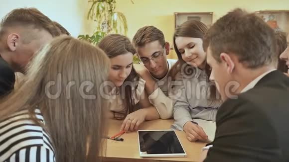 同学们围坐在课桌旁用平板讨论学校的任务俄罗斯学校视频的预览图