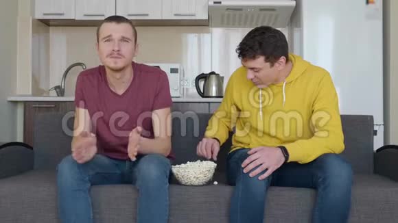 两个男人正在看足球赛吃爆米花视频的预览图