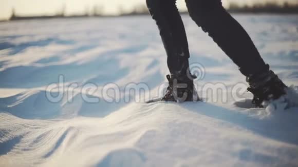 日落时分女人的脚在雪地沙漠上行走慢动作射击视频的预览图