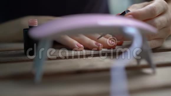 一位女士用在紫外线下变硬的凝胶抛光来修指甲视频的预览图