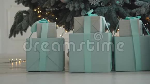 把圣诞礼物放在树下的盒子里关上视频的预览图
