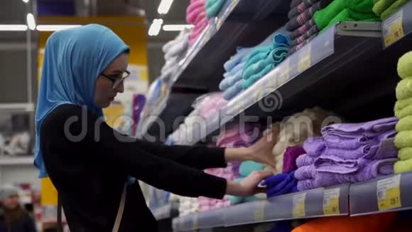 有吸引力的穆斯林女孩购物选择面料衣服视频的预览图