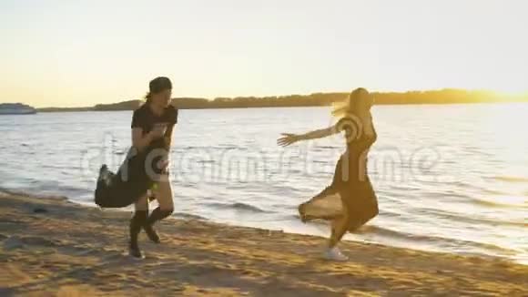 两个穿着黑色裙子的女孩沿着海滩散步跳舞视频的预览图