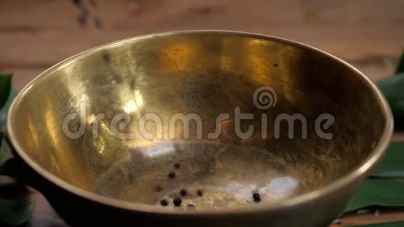 整块和磨碎的黑色胡椒在旧木桌上倒在碗里栎类品种磨制黑胡椒视频的预览图