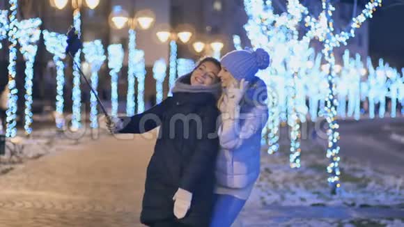 两个女朋友晚上在冬季公园自拍视频的预览图
