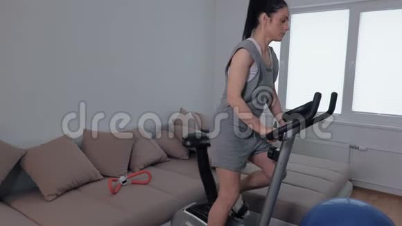 女人骑着固定的自行车做运动视频的预览图