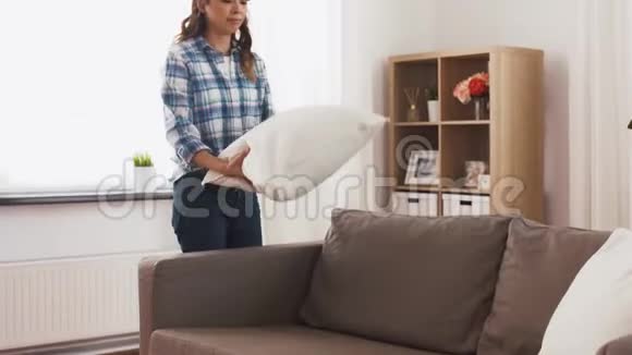 亚洲女人在家里布置沙发靠垫视频的预览图