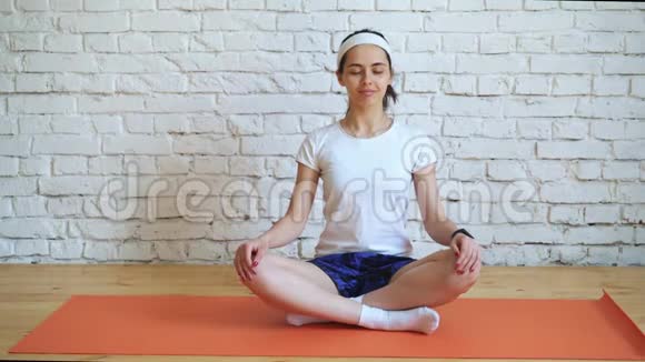 一个漂亮的聪明的运动的女孩在健身房里做瑜伽运动有阁楼风格自然采光大视频的预览图