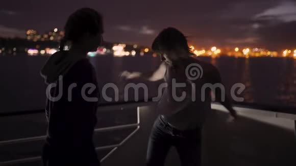 两个美丽的年轻女子在船甲板上跳舞的剪影船上的女朋友视频的预览图