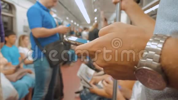 地铁列车上的人在智能手机上通过社交媒体读取信息慢动作视频乘客视频的预览图