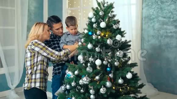 幸福的家庭一起装饰圣诞树父亲母亲和儿子视频的预览图