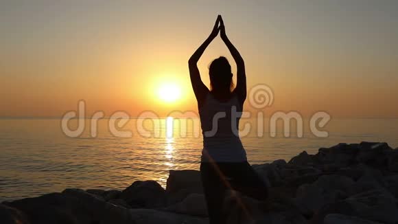 女人早上在海滨冥想女人在海滨练习瑜伽视频的预览图