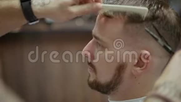 理发店理发师剪胡子的英俊留胡子的男人视频的预览图