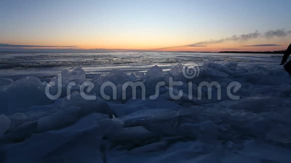 日出时一个人走在湖岸的冰上一个男人的剪影视频的预览图