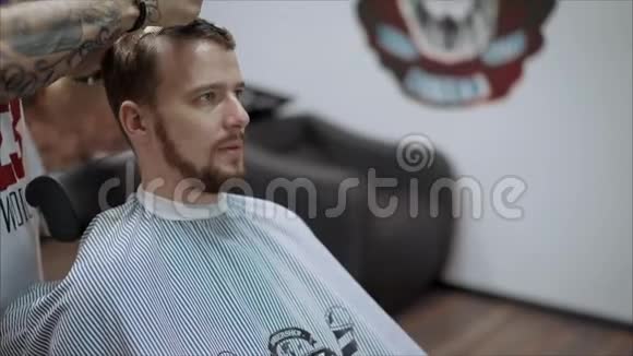 理发店理发师剪胡子的英俊留胡子的男人视频的预览图