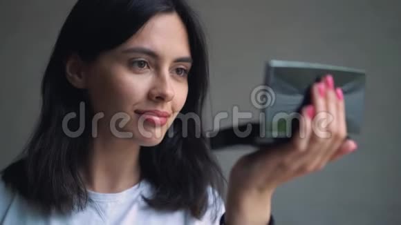 美少女涂睫毛膏对着镜子欣赏自己美丽的学生女孩在看视频的预览图